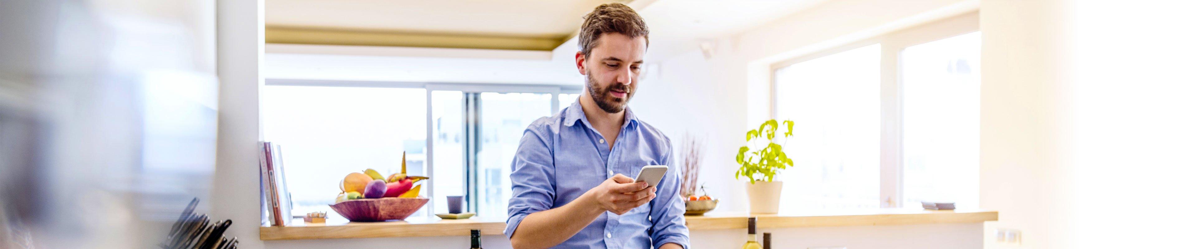 Person wearing a smart watch and holding out a smart phone