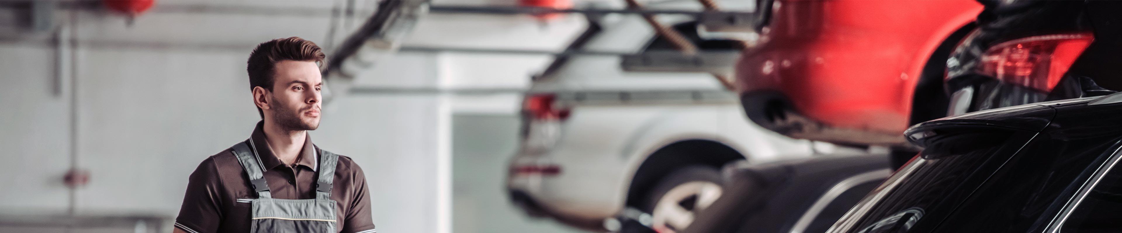 A mechanic walks around a garage inspecting vehicles