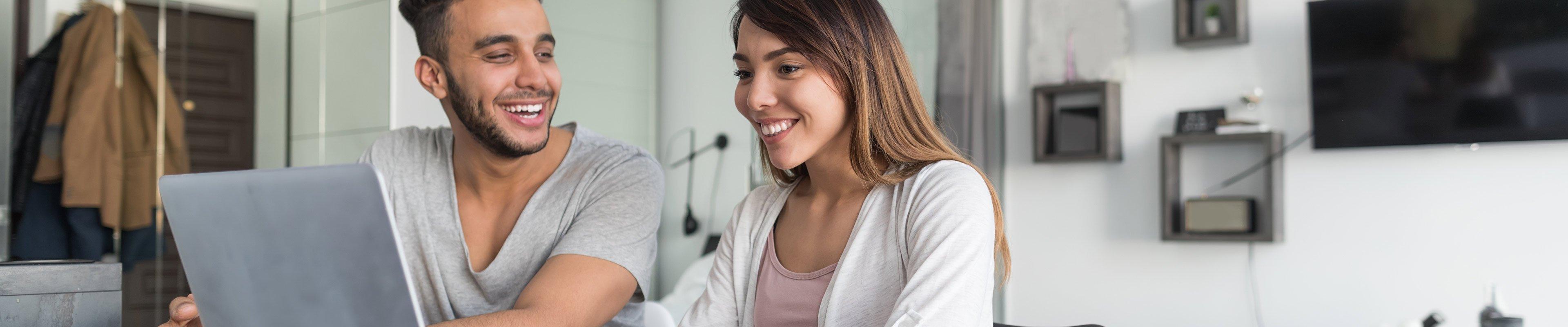 Two people sitting at a table comparing home insurance quotes.