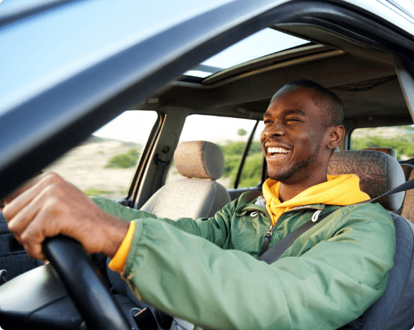 A happy person driving their car on a sunny day.