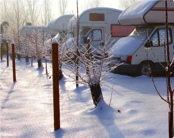 line of RVs sitting in a parking lot in snow