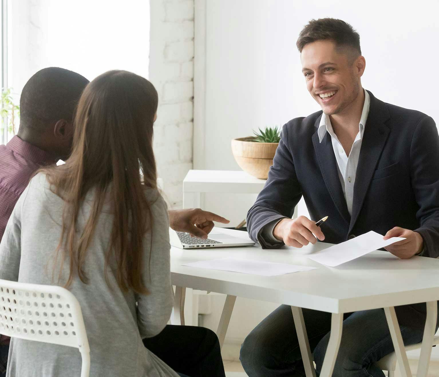 Image of a young couple reviewing their life insurance policies with their insurance agent.