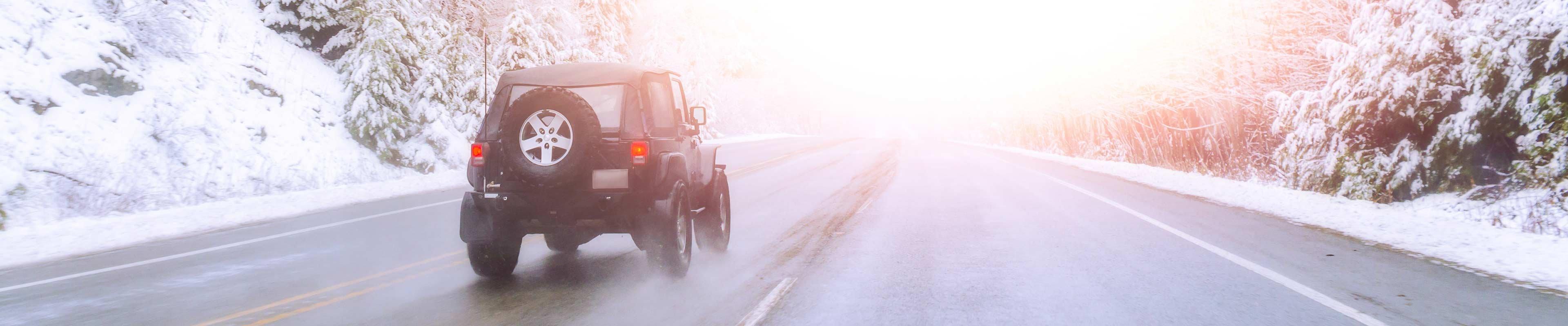 Car driving down highway in winter