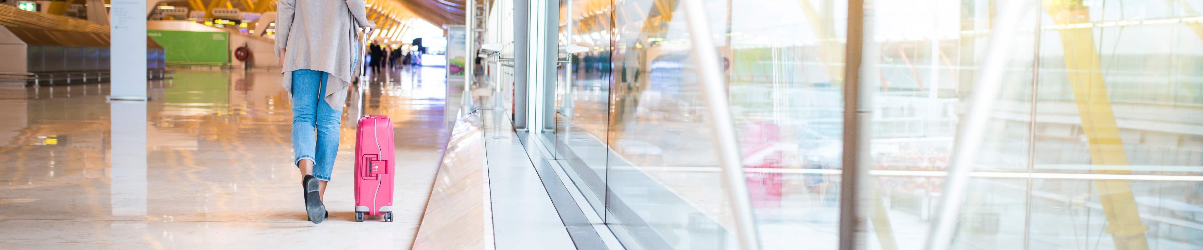 woman traveling through an airport with her luggage