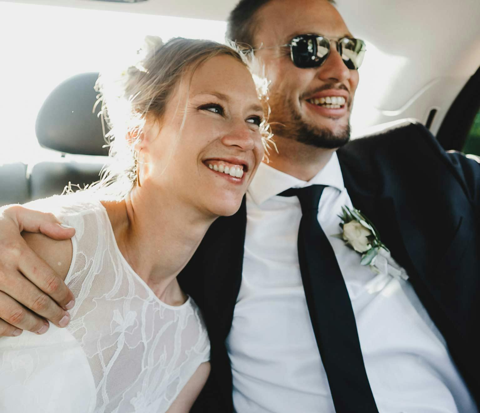 Image of a newlywed couple in their car.