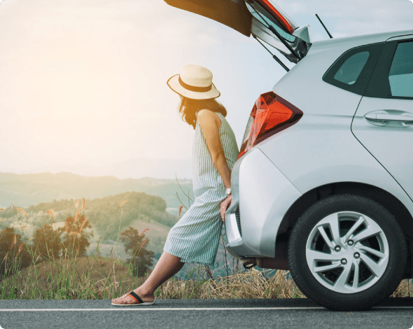 Woman leaning on the back bumper of her car