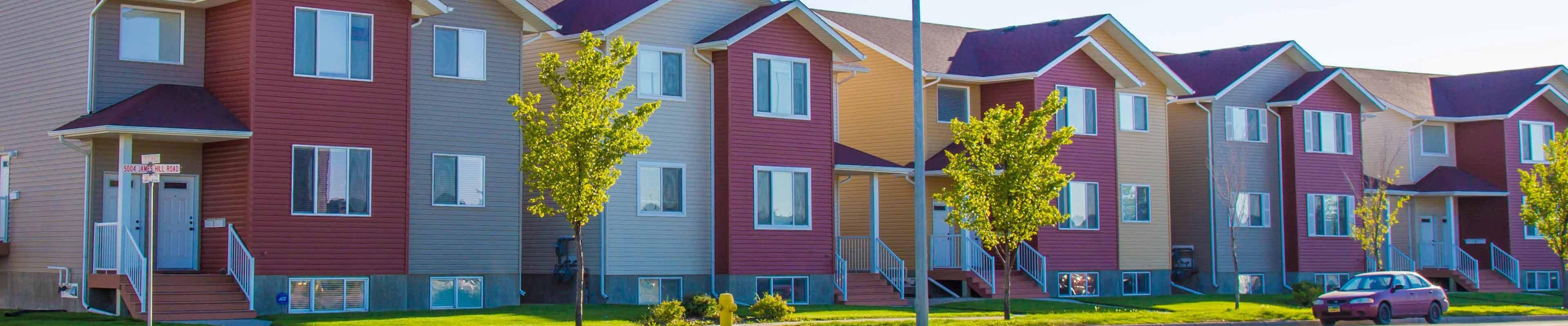 Image of a row of brightly colored multi-unit rental properties.