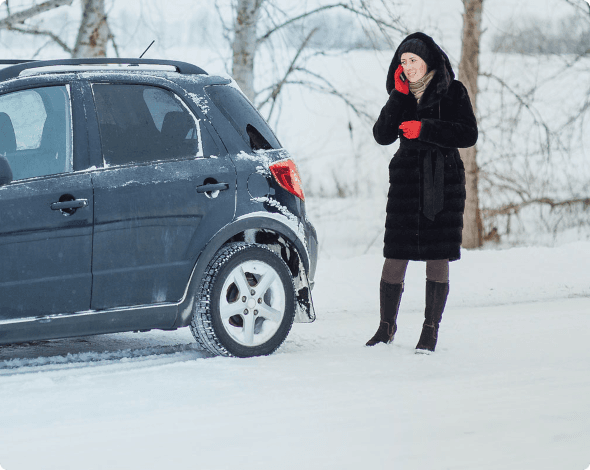 a woman on the phone next to her stranded car